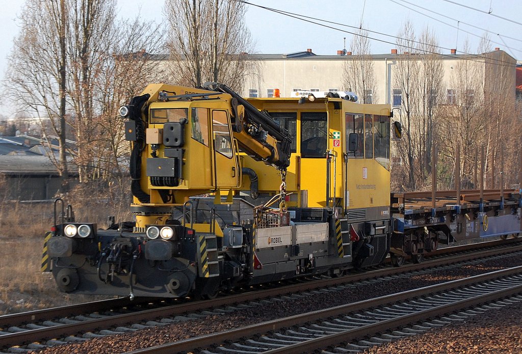 BAMOWAG 54.22 der DB Netz Instandhaltung mit Drehgestelflachwagen mit Schienen beladen Richtung Blankenburg, 05.03.12 Berlin-Pankow.
