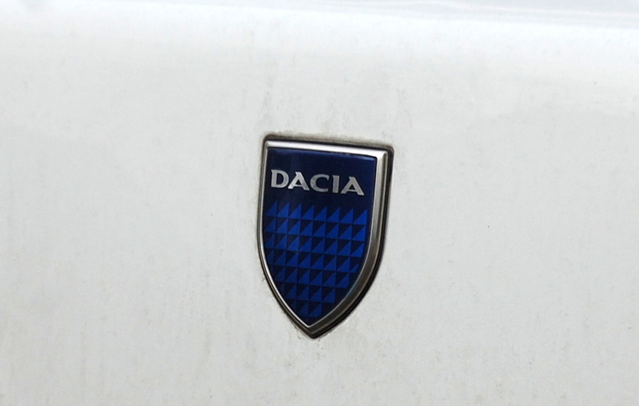 Der rummnische Autohersteller Dacia (SC Automobile Dacia SA) wurde 1966 gegrndet und kooperierte von Anfang an eng mit dem franzsischen Hersteller Renault. 1999 erwarb der Konzern Renault-Nissan alle Firmenanteile, der Name blieb allerdings, dieses blaue Herstellerlogo ziert nun seit lngerem die neueren Dacia-Modelle.