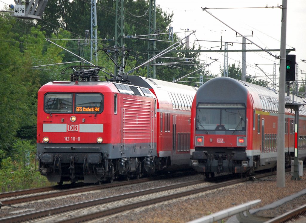 Der versptete RE5 mit 112 111-0 Richtung Rostock Hbf begegnet dem RE3, 11.08.10 Berlin-Blankenburg. 