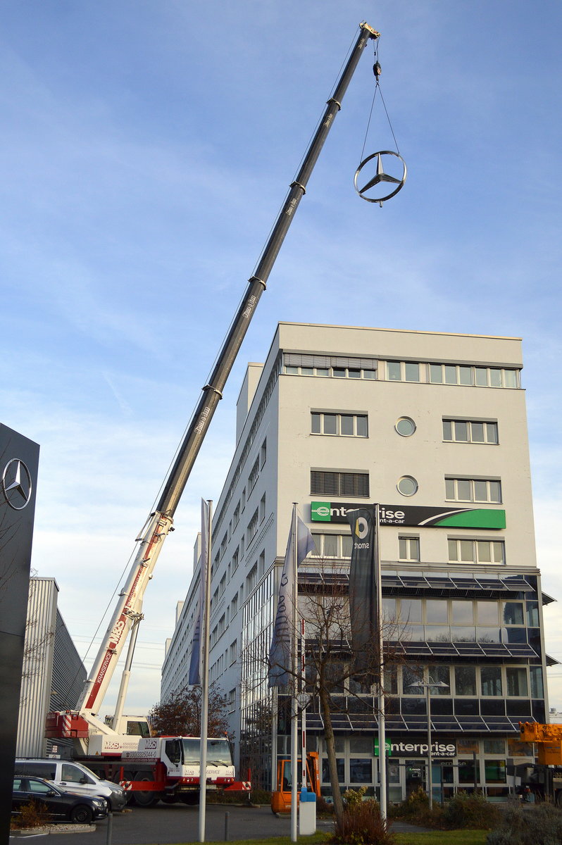 Ein M&S Kranservice LIEBHERR LTM 1070? Fahrzeugkran hebt einen neuen Mercedes-Stern auf ein Geschäftsgebäude, 21.11.16 Berlin-Marzahn.
