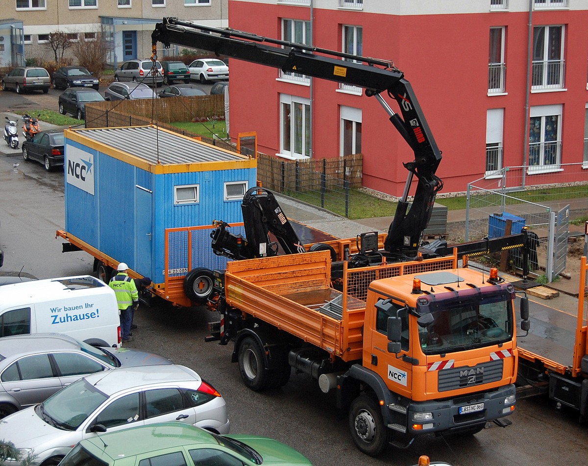 MAN TGM 18.330 Baukipper (Selbstlader) der Fa.NCC verlädt einen Bauaufenthaltscontainer auf Hänger, 09.12.13 Berlin-Pankow. 