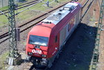 OHE Cargo GmbH 270082 (223 103-3) holt einen Zug leerer Stammholz-Transportwagen gegenüber dem Berliner Westhafen ab, 21.04.16 Berlin-Putlitzbrücke.