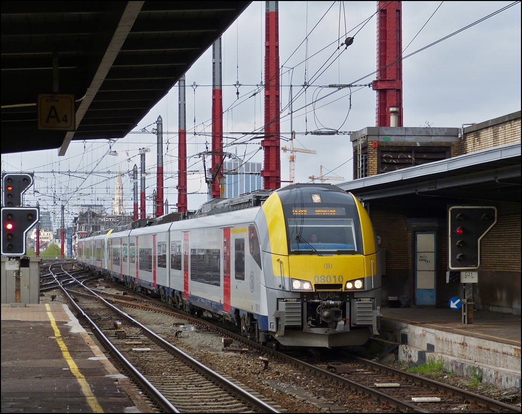 . Der neue Triebzug AM (Automotrice) 08 010 f�hrt am 10.05.2013 zusammen mit einer zweiten AM 08 in den Schmuddelbahnhof Bruxelles Midi ein. (Hans)

Diese Triebz�ge sollten ab 2011 die klassischen SNCB Triebz�ge (AM 62-73) ersetzten, doch es gab enorme Schwierigkeiten, um sie an das belgische Stromsystem zu  gew�hnen . Heute fahren sie auf einigen Strecken, aber lange noch nicht �berall. 

In Br�ssel konnten wir �brigens viele Desiros beobachten, die schon von oben bis unten mit Graffiti besaut waren. Einfach nur schade um die nagelneuen Z�ge.

Die technischen Daten der S�rie AM 08:

Die Baureihe AM 08 der Belgischen Staatsbahn (NMBS/SNCB) ist eine Bauart von Einzelwagentriebz�gen, die zur modular aufgebauten Produktfamilie Desiro ML von Siemens Mobility (vormals Siemens Transportation Systems) geh�ren. 305 dreiteilige, elektrische Triebz�ge befinden sich seit Ende 2009 in Produktion. Die ersten Fahrzeuge sollten 2011 in Dienst gestellt werden.

Die Fahrzeuge besitzen Niederflureinstiege mit einer Breite von 1,3 Metern, ebenfalls befinden sich alle Sitzpl�tze niederflurig, wobei der gr��ere Teil stufenlos erreichbar ist. Es werden barrierefreie Zustiege und Wagendurchg�nge sowie ein behindertengerechtes WC installiert. Die Fahrzeuge sind voll klimatisiert. Ein optisches und akustisches Fahrgastinformationssystem informiert die Passagiere. Konventionelle Drehgestelle des Typs SF6500 aus dem Siemens-Werk in Graz sollen zur kosteng�nstigen Instandhaltung beitragen. Sie besitzen unter anderem bew�hrte Schwingenf�hrungen, Schraubenfedern und eine sekund�re Luftfederung und sind damit eine direkte Weiterentwicklung der Drehgestelle des Typs SF6000, die im Sprinter Lighttrain zum Einsatz kommen. Die Befahrbarkeit von engen Gleisradien bis zu 80 Metern ist m�glich.

Die Triebz�ge werden mit dem Zugsicherungssystem Trainguard 100 (ETCS Level 1) sowie mit Trainguard-Ger�ten angebundenen Ausstattungen des belgischen Systems TBL 1+ versehen. Ohne Fahrtunterbrechung kann zwischen beiden Systemen umgeschaltet werden.

Die Triebz�ge k�nnen in Mehrfachtraktion gefahren werden.

Hersteller ist Siemens Mobility - ein Gesch�ftsbereich der Siemens AG. Die Produktion findet seit 2009 in dessen Werk in Krefeld-Uerdingen statt. Die Inbetriebsetzung und Kundenabnahme erfolgte im Pr�fcenter Wegberg-Wildenrath. Ein Teil der Z�ge wird teils vor Ort bei Bombardier Transportation gefertigt.

Am 15. Mai 2008 gab die Belgische Staatsbahn insgesamt 305 dreiteilige Desiro ML f�r 1,4 Milliarden Euro bei Siemens in Auftrag. Die Auslieferungen sind f�r die Jahre 2011 bis 2016 vorgesehen. 95 der Fahrzeuge sind f�r das RER-Netz in Br�ssel eingeplant, au�erdem sollen die mehrspannungsf�higen Fahrzeuge auf den mit 25 kV Wechselspannung elektrifizierten Strecken in den Ardennen, wie bspw. Libramont–Athus, eingesetzt werden und dort die Reihe 41 abl�sen.

Nummerierung: 08 001–095 (3 kV =, f�r GEN/RER Br�ssel) 08 501–595 (3 kV = + 25 kV ~)
Anzahl: 305 Dreiteiler
Hersteller: Siemens Mobility
Baujahr(e): seit 2009
Achsformel: Bo'Bo'+2'2'+Bo'Bo'
Spurweite: 1435 mm (Normalspur)
L�nge �ber Kupplung: 79.907 mm
Drehzapfenabstand: 18.62 mm
Leermasse: ca. 145 t
Radsatzfahrmasse: <17 t
H�chstgeschwindigkeit: 160 km/h
Stundenleistung: 2.000 kW
Beschleunigung: 1,1 m/s�
Stromsystem: 	210 Z�ge: 3 KV DC   92 Z�ge: 25 KV AC/50 Hz und 3 KV DC   
Strom�bertragung: Oberleitung
Sitzpl�tze: 280
Stehpl�tze: 280
Fu�bodenh�he: 800 mm �. SoK


