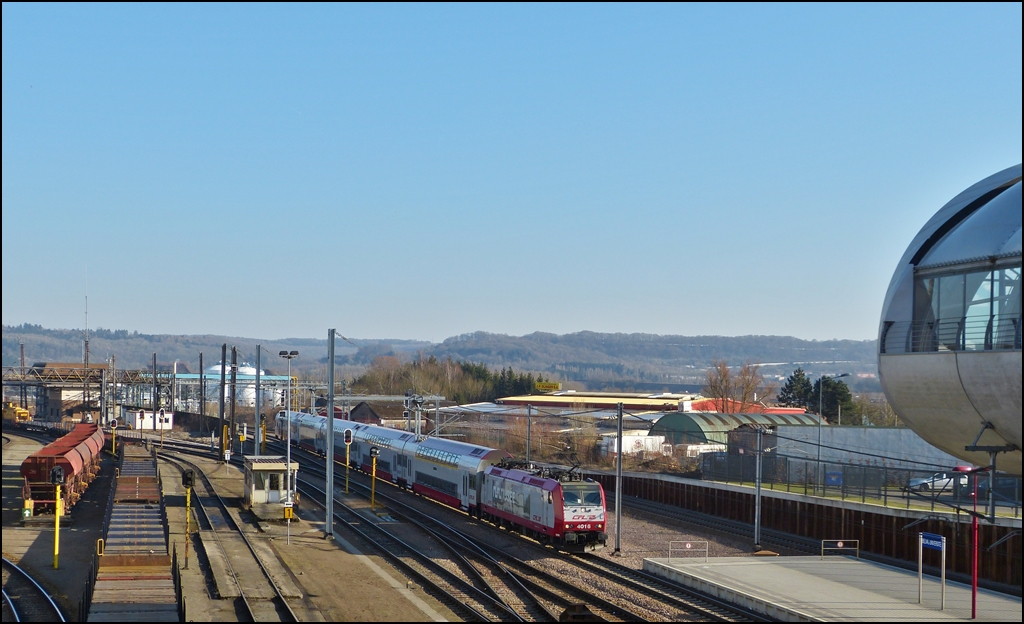 . Von der Fu�g�ngerbr�cke, welche den Bahnhof Belval Universit� mit der Industriebrache Esch Belval verbindet, konnte ich am 04.03.2013 die 4016 mit dem RE 6965 Luxembourg - Rodange bei der Einfahrt in den Bahnhof fotografieren. Am linken Bildrand ist noch die CFL Cargo Diesellok 318 zu sehen, welche die Flachwagen durch den Verschiebebahnhof Esch Belval dr�ckte, sie wurde aber leider Opfer des Ausrichtens. (Jeanny)