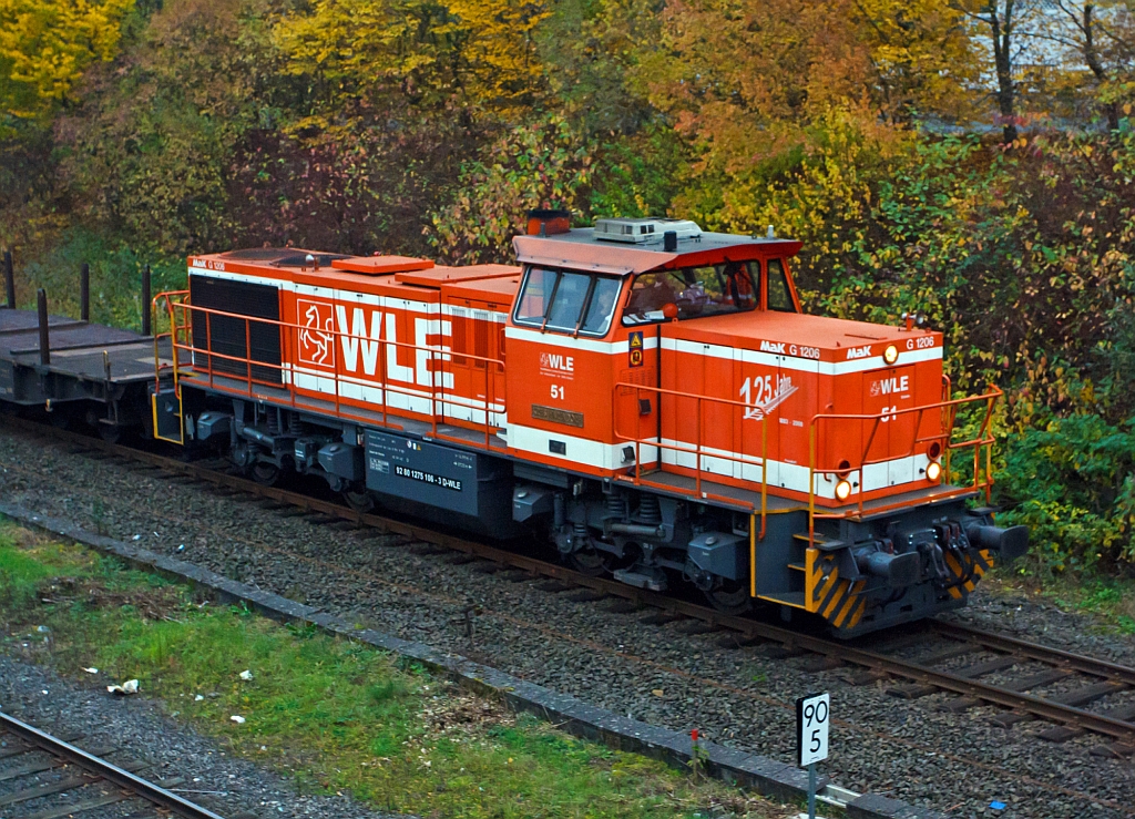 Als Lokportrait - Die WLE (Westf�lische Landes-Eisenbahn) Lok 51  Kreis Warendorf  (eine MaK G 1206) kommt mit leeren G�terzug (Schwerlastwagen) von Burbach-Holzhausen �ber die Hellertalbahn (KBS 462), hier am 25.10.2012 in Herdorf (km 90,5) kurz vor der Br�cke Wolfsweg. Die Lok wurde 2002 bei Vossloh unter Fabriknummer 1001150  gebaut. Die komplette NVR-Nummer ist 92 80 1275 106-3 D-WLE.