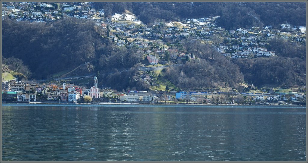 Bei Vira, kurz vor dem Bahnhof Magadino-Vira zieht vermutlich eine SBB Re 474 einen G�terzug Richtung Norden.
Das Bild entstand vom Schiff aus. 
21. M�rz 2013