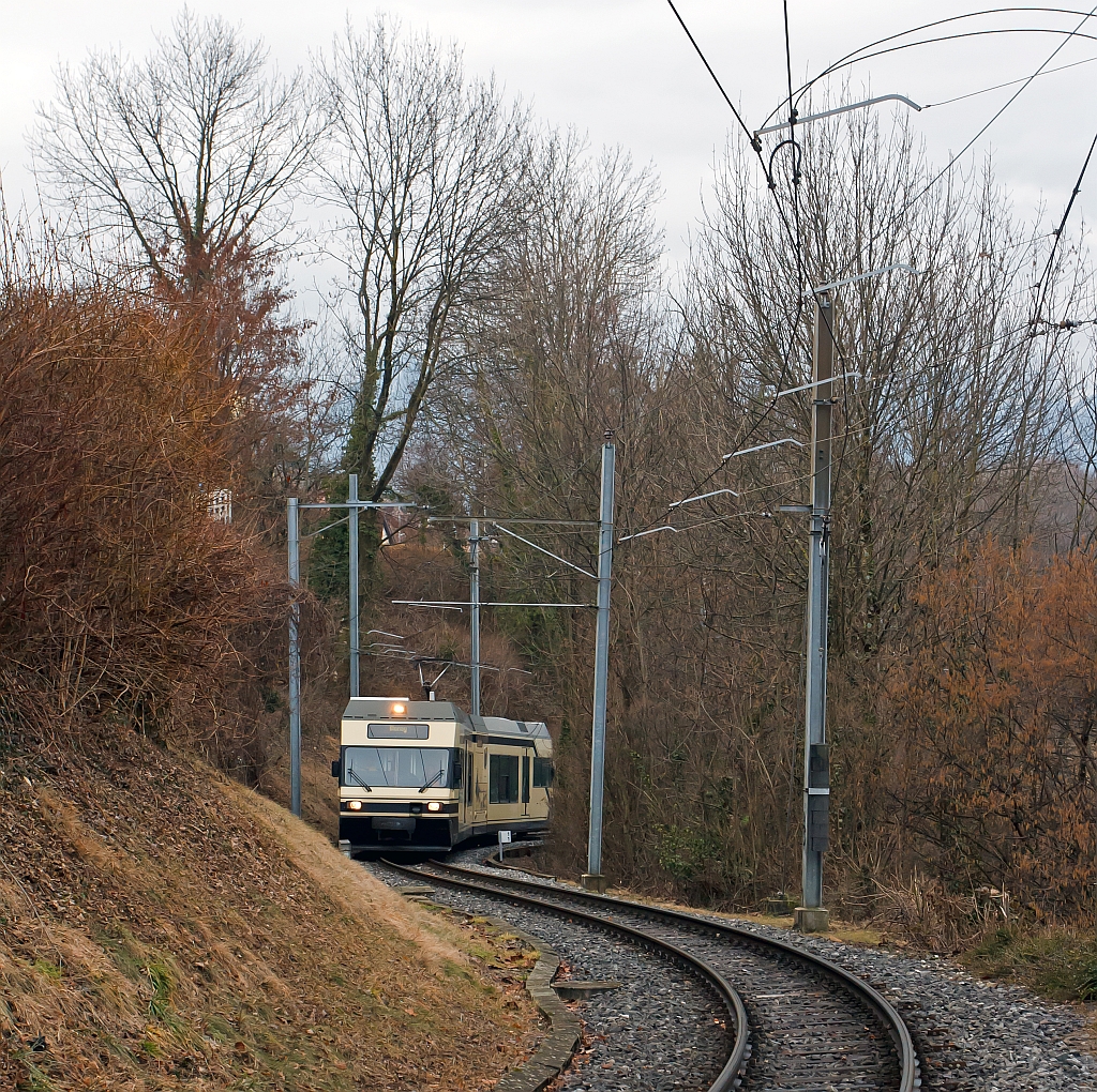 Der Be 2/6 - 7001 (Stadler Elektrischer Niederflur-Doppelgelenk-Leichttriebwagen Typ GTW 2/6) der MVR (Transports Montreux–Vevey–Riviera) ex CEV (Chemins de fer �lectriques Veveysans) schl�ngelt sich von Vevey hinauf, hier am 26.02.2012 kurz vor dem Haltepunkt Gilamont. Die Meterspurige 900 V Gleichstrom-Strecken Vevey–Blonay, hat eine Steigung bis zu 45 promile.