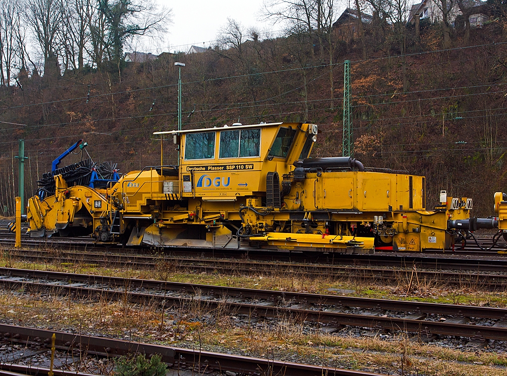 Deutsche Plasser Schotterverteil- und Planiermaschine SSP 110 SW (Schweres Nebenfahrzeug Nr. 97 16 40 549 18 - 6) der DGU (Deutsche Gleisbau Union), abgestellt am 10.03.2013 in Betzdorf/Sieg.

Der Schotterpflug wurde 1995 unter der Masch.-Nr. 607  bei der Deutsche Plasser gebaut.

Schotterpfl�ge werden vor oder nach dem Stopfen des Gleises eingesetzt. 
Die Maschinen bewirken eine optimale Schotterverteilung und Formen das Profil des Schotterbettes. Dies ist notwendig f�r den Seitenwiederstand des Schotterbettes. Der Schotterpflug SSP 110 SW ist mit einem Schotterbunker von 5 m� ausgestattet. Der Schotterpflug SSP 110 SW kann sowohl f�r Gleis- als auch Weichenschotterplanierarbeiten eingesetzt werden.

Technische Daten: 
Eigengewicht: 37 t
L�nge �ber Puffer: 17.500mm
Achsanzahl: 2 
Motorleistung: 235 kW
Fahrgeschwindigkeit mit Eigenantrieb: 90 km/h
zul. Streckenklasse: B2 oder h�her