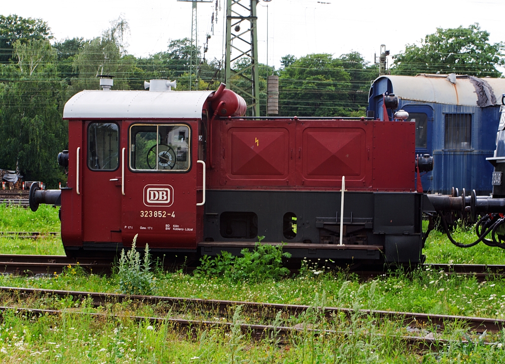 Die DB 323 852-4, ex DB K�f 6782 im DB Museum in Koblenz am 18.07.2012. 
Die K�f II wurde 1960 von Jung, Jungenthal bei Kirchen a.d. Sieg unter der Fabriknummer 13220 gebaut und als K�f 6782 ausgeliefert. Die Umbezeichung erfolgte 1968, in K�ln-Gremberg wurde sie 1998 ausgemustert. 
Die Lok hat eine Leitung von 128 PS und eine H�stgeschwindigkeit von 45 km/h.

Diese Loks waren sehr klein, sie hatten Regelspurbreite, f�llten aber das Lichtraumprofil nach oben nur zur H�lfte aus. Dadurch konnten sie zur �berf�hrung auf Flachwagen verladen werden.