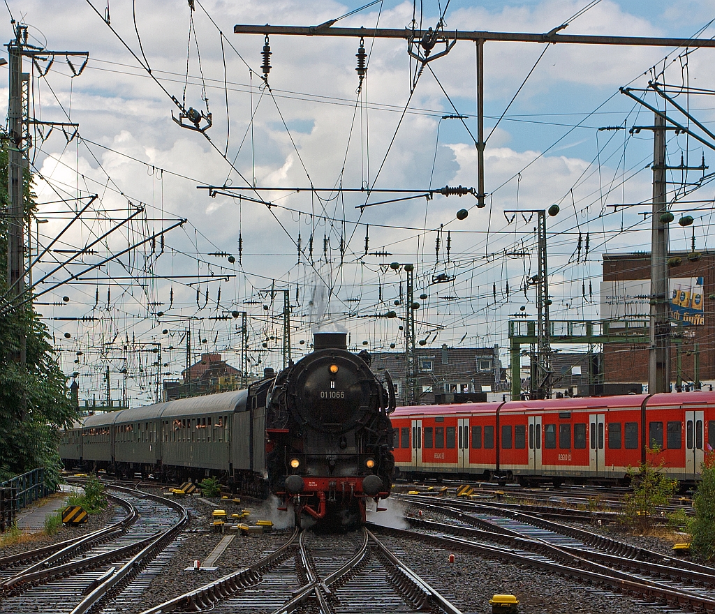 Die Dreizylinder-Schnellzuglokomotiven 01 1066 ex DB 012 066-7 der UEF am 07.07.2012 mit einem Sonderzug bei der Einfahrt in den Hbf K�ln. Bemerkenswert ist das der Zug aus 12 vollbesetzten Wagen bestand und alleine von der 01 gezogen wurde. 
Die 011066 wurde im Jahr 1940 von der BMAG (vormals L. Schwartzkopff) an die Deutsche Reichsbahn ausgeliefert. Urspr�nglich hatte die Lok eine Stromlinienverkleidung, die aber nach dem Ende des 2. Weltkriegs entfernt wurde. 
Im Jahr 1954 bekam die 011066 einen neuen Hochleistungskessel, 1957 eine �lhauptfeuerung. Am 31. Mai 1975 absolvierte die Lok ihre letzte planm��ige Fahrt bei der DB.