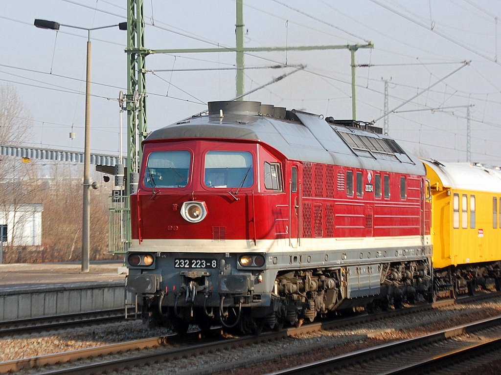 Die ex DGT jetzt DB Bahnbau Gruppe Lok 232 223-8 (Lugansk Bj.1975) mit einem Bauzug bzw. Umbauzug aus diversen Wagen und dem P&T SUM-314  Mamut  bestehend bei der Durchfahrt im Bhf. Flughafen Berlin-Schnefeld, 15.02.11. 