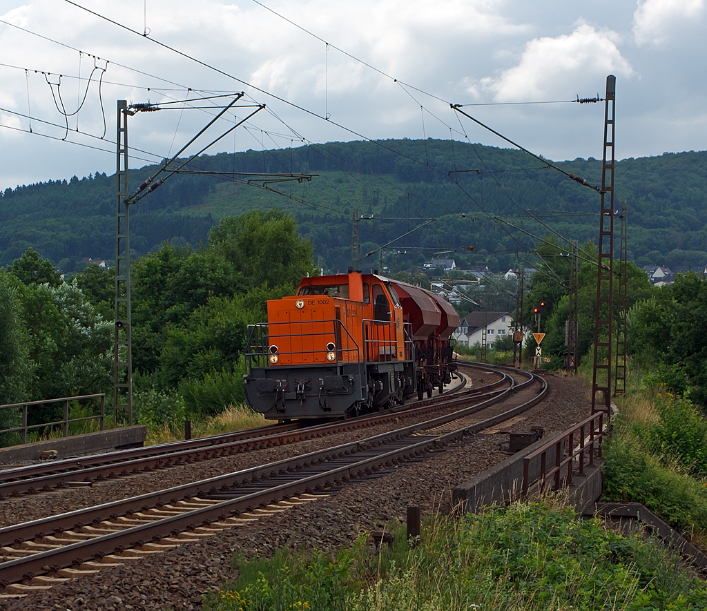 Die Lok 41 (eine MaK DE 1002) der Kreisbahn Siegen-Wittgenstein (KSW), zieht am 11.07.2013 bei Haiger zwei Gedeckte Sch�ttgutwagen mit dosierbarer Schwerkraftentladung und zwei Rads�tzen (Tds 937) in Richtung Siegen. Diese Wagen werden verwendet f�r den Transport von Ammoniumnitrat welches unteranderem zur Sprengstoff Herstellung dient.
Auf Grund der Gleisbaustelle auf der Hellertalbahn musste sie �ber Haiger nach Siegen (�ber die KBS 445 - Dillstrecke) fahren. 
Die DE 1002 wurde 1988 bei MaK unter der Fabriknummer 1000832  gebaut und an die HEG - Hersfelder Eisenbahn GmbH  als 832 geliefert.  Nach Einstellung des Bahnbetriebes der HEG ging sie konzernintern an HLB - Hessische Landesbahn GmbH Lok 832 und 1996 wurde sie an die fr�here Siegener Kreisbahn GmbH als Lok 41 verkauft, die heute als Kreisbahn Siegen-Wittgenstein firmiert.
Die Lok hat heute die NVR-Nummer 98 80 0272 008-0 D-KSW und die  EBA 02B20K 001.
Gegen�ber den 16 Loks dieses Typs der HGK hat diese Lok einen  MTU 12V396TC13 Motor mit 1.120 kW (1.523 PS) Leistung. Die Leistungs�bertragung erfolgt einen Generator auf 4 elektrische (Drehstrom) Fahrmotoren. Generator und die Fahrmotoren sind von BBC (heute ABB).
Die Lok hat eine H�chstgeschwindigkeit von 90 km/h.