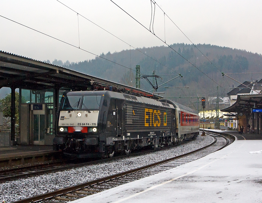 Die MRCE-Dispolok 189 115-9 (ES 64 F4 - 115) zieht, bei leichten Schneefall, den DB-Autozug AZ 1339 am 19.02.2013 durch den Bahnhof Betzdorf/Sieg in Richtung Rhein. 

Die Lok wurde 2009 von Siemens unter der Fabriknummer 21521 gebaut. Sie hat die UIC-Nr. 91 80 6189 115-9 D-DISPO/I-SAD 

Die BR 189 (Siemens ES64F4) ist eine Variante der EuroSprinter-Lokfamilie mit Vier-Stromsystem-Ausstattung. Sie ist in allen vier in Europa �blichen Bahnstromsystemen einsetzbar.  

Sie haben bei 15 kV / 25 kV ~ eine Stundenleitung von 6.400 kW, eine Anfahrzugkraft von 300 kN, eine H�chstgeschwindigkeit von 140 km/h, die Achsformel ist Bo’Bo’