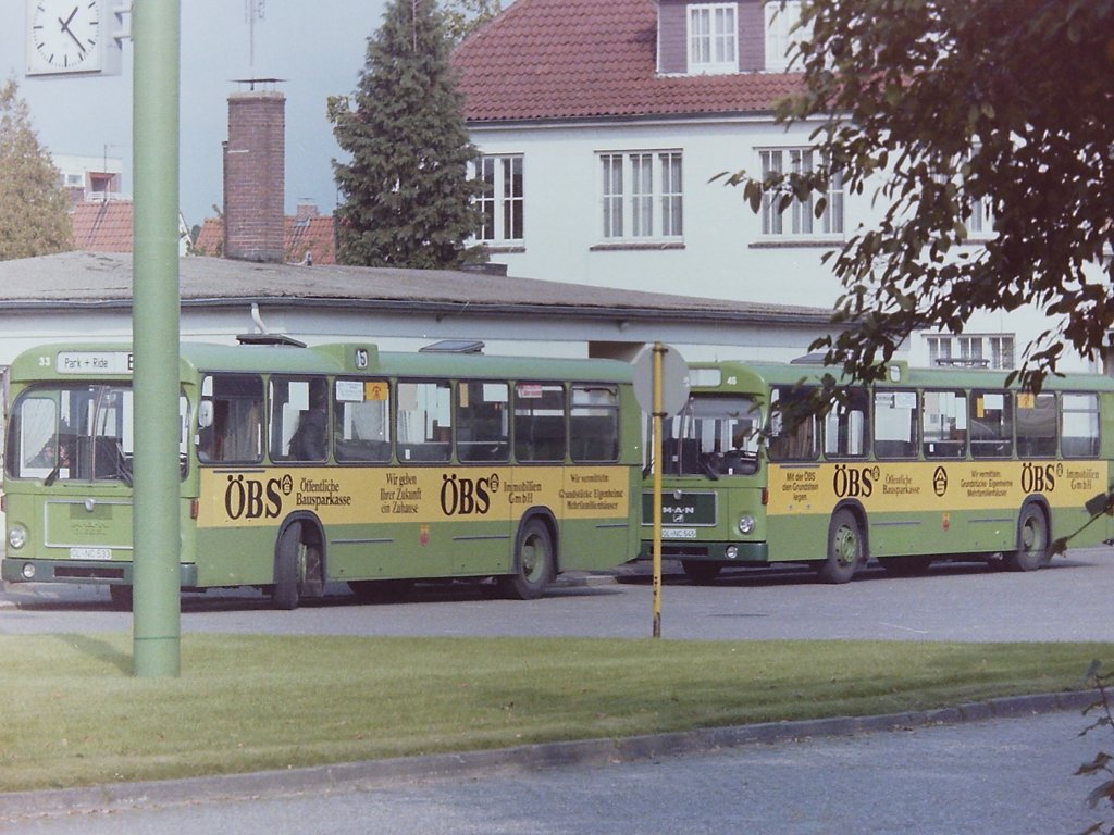 Die �BS-Busse. Auf keiner Aufnahme werden die teilweise erheblichen Unterschiede so deutlich wie auf dieser. Sie zeigt Wagen 33 und Wagen 45 im Oktober 1985. Beide Busse stehen bereit um in den Sonderfahrplan zum Kramermarkt zu starten. Auf keinem anderen Bus war aber auch die Beschriftung so derma�en  verr�ckt  worden, wie auf Wagen 33. Au�erdem ist er der einzige Bus auf dem der Slogan  Wir geben ihrer Zukunft ein zuhause  steht, der sp�ter zur LBS-Werbung geh�rte, statt  Mit der �BS den Grundstein legen . Ganz nebenbei f�llt hier nat�rlich auch der hellgr�ne K�hlergrill ins Auge, den Wagen 33 als einziger �BS-Bus trug. 