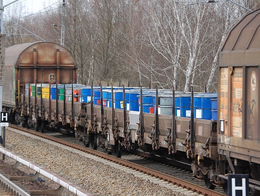 Drehgestellflachwagen mit vier Radstzen und Rungen beladen mit farbigen Tonnen (Inhalt?) am 31.03.11 Mhlenbeck-Mnchmhle.