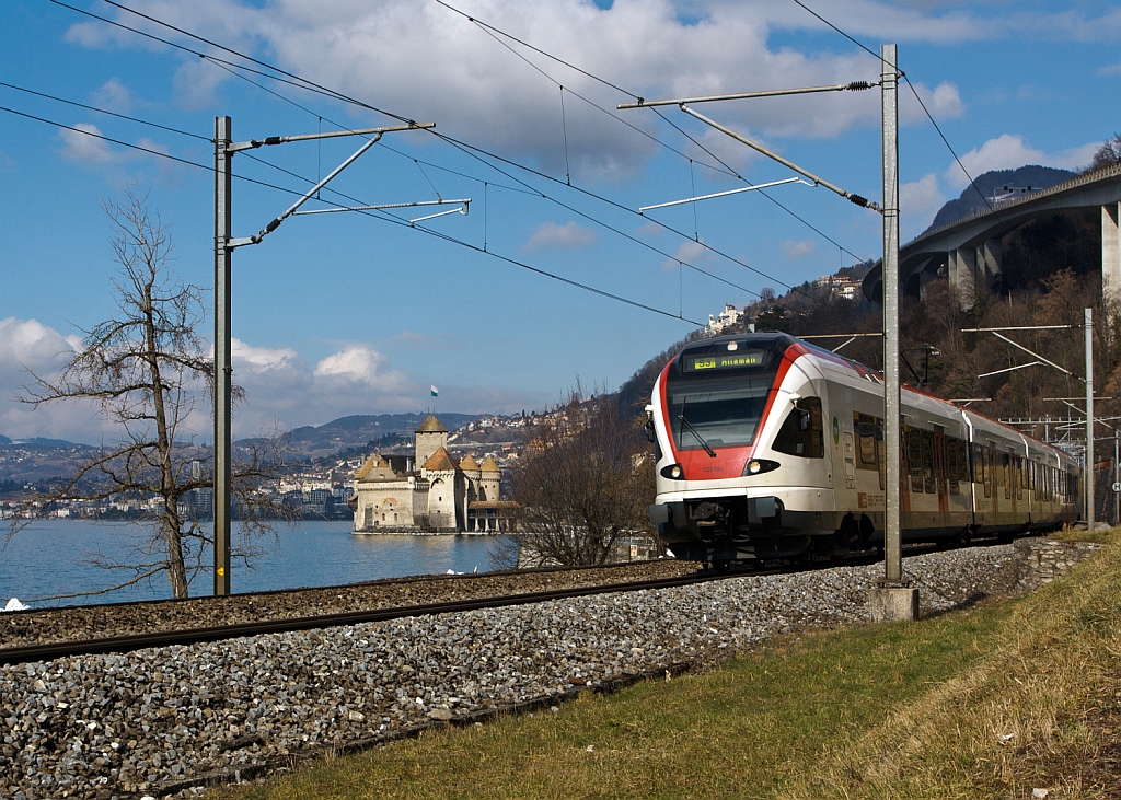 Ein Stadler FLIRT  RABe 523 030 der SBB (RER Vaudois) als S3 (Allaman–Lausanne–Vevey –Montreux–Villeneuve), f�hrt am 26.02.2012 bei  Clos du Moulin am Genfersee Richtung Villeneuve, hinten Ch�teau de Chillon, dahinter Montreux.