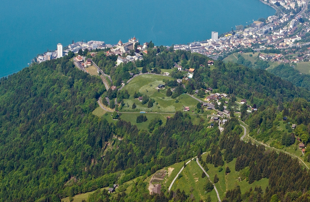 Ein Zug Suchbild: Blick vom Gipfel des Rochers-de-Naye am 26.05.2012. Der Triebwagen Bhe 4/8 303 Villeneuve wartet bereits im Kreuzungsbahnhof Caux und der Triebwagen Bhe 2/4 203 ist auf Talfahrt.