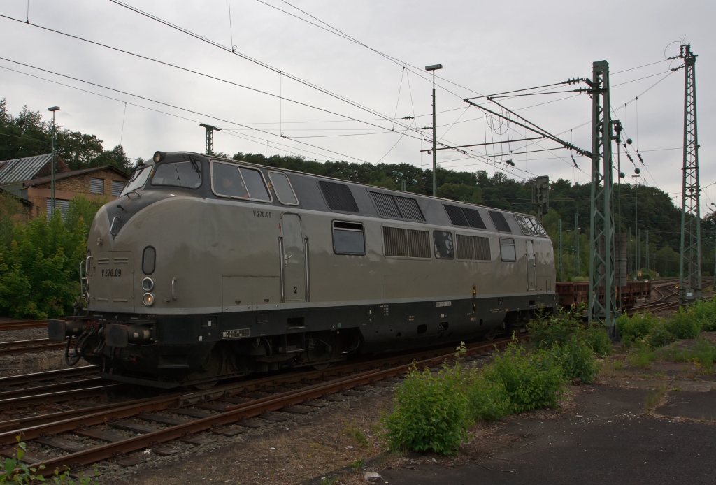 Eine graue Maus, aber nur in der Lackierung: Die V270.09 (eine V200.1) der SGL Schienen-G�ter-Logistik GmbH f�hrt am 17.07.2011 von Betzdorf/Sieg in Richtung Siegen los. Die Lok wurde 1964 von Krauss-Maffei unter der Fabrik-Nr. 19241 als V 200.121 (221 121) gebaut. Sie hat eine Leistung von 2x 990 kW (bzw. 1346 PS).
Die V200.1 habe Motoren mit h�herer Leistung als die V200.
In altrot w�rde sie mir doch noch besser gefallen.