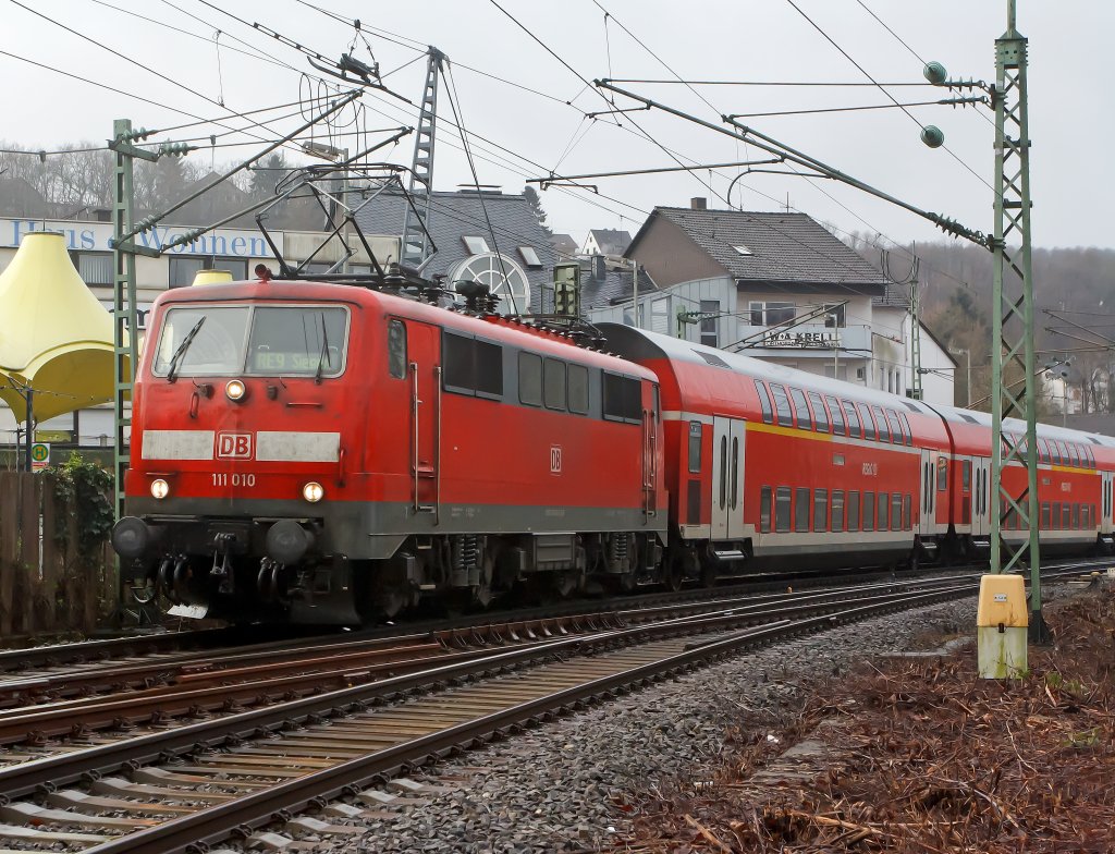 Es wird wieder Sandwich gefahren: Der RE 9 (Rhein-Sieg-Express) Aachen - K�ln - Siegen, hat hier am 08.01.2012 den Bahnhof Betzdorf/Sieg verlassen und f�hrt weiter in Richtung Siegen. Die Zuglok ist 111 010 und Schublok 111 075-8. Es sind wohl wieder Loks f�r diesen Einsatz frei.