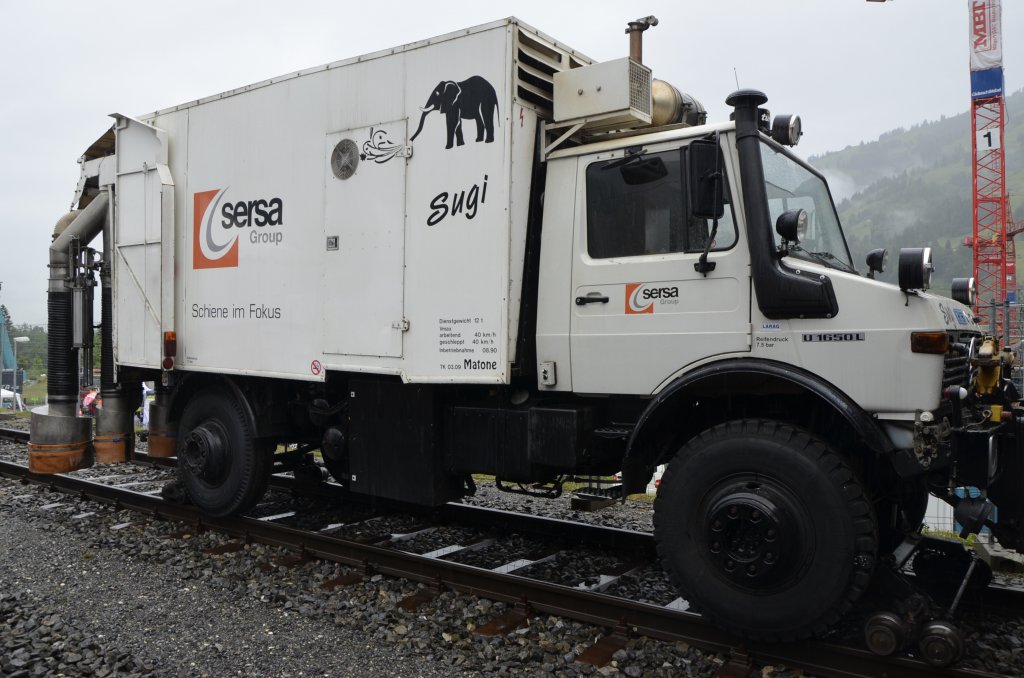 Gleisreinigungsfahrzeug „Sugi“:  Gr�ndliche S�uberung der Gleisstrecken durch Absaugen von groben Abf�llen und feuchten Materialien wie Papier und Laub, auch im Tunnel  so steht es in der Produktbeschreibung von Sersa.
Hersteller: Zweiweg, Typ ZW 100 S, 
Basisfahrzeug: MB-Unimog U 1650 L 
Baujahr: 1990
Fabriknummer: 1295
Stra�enkennzeichen: ZH 1732
Das Fahrzeig wurde auf der Jubil�umsausstellung 100 Jahre L�tschbergbahn in Frutigen pr�sentiert (29.06.13).
