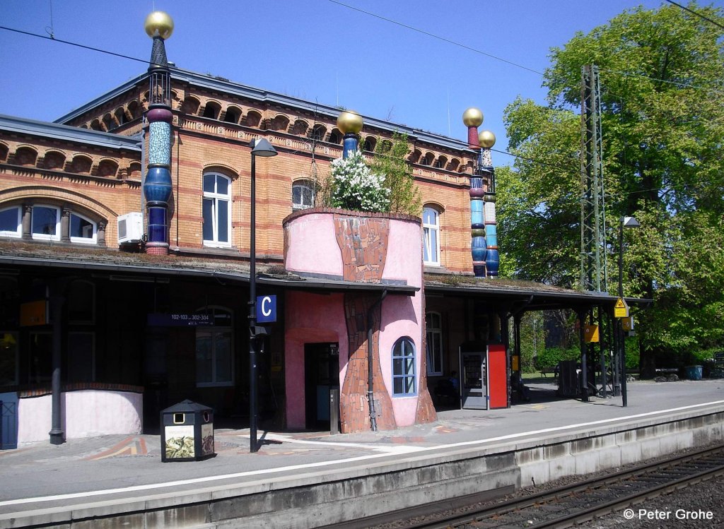 Gleisseite vom Empfangsgeb�ude Bahnhof Uelzen --> Der Bahnhof wurde vom �sterreichischen K�nstler Hundertwasser entworfen und von 1999 bis 2001 zum   Kulturbahnhof   umgebaut. Es gibt dort viele sehenswerte Details wie z.B. das T�rmchen in der Mitte: = Liftschacht mit Dachgarten!
fotografiert am 06.05.2011