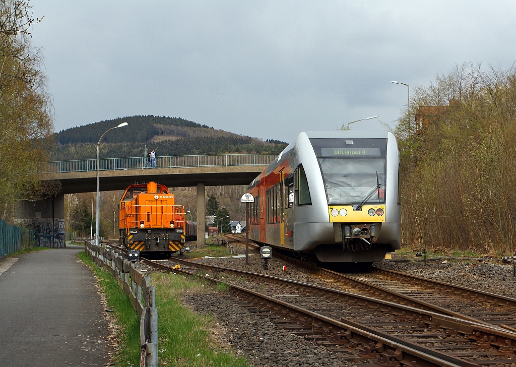 Herdorf, den 16.04.2012: Links auf dem KSW-Gleis, die Gleissperre ist noch geschlossen, steht die Lok 46 der KSW (Kreisbahn Siegen-Wittgenstein), eine Vossloh G 1700-2 BB (eingestellt als 92 80 1277 807-4 D-KSW),  mit dem G�terzug zur �bergabefahrt bereit. Rechts auf dem DB-Gleis (Hellertalbahn - KBS 462) f�hrt ein GTW 2/6 der Hellertalbahn in Richtung Dillenburg.