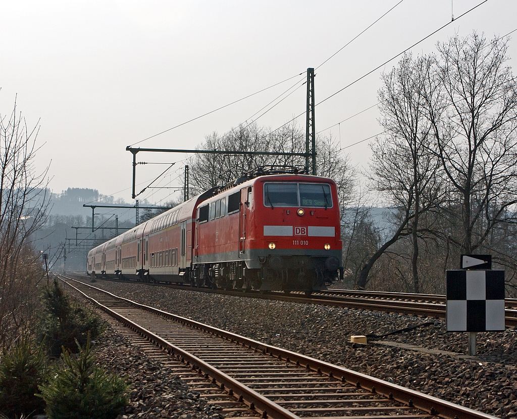 Im Gegenlicht: 111 010 mit dem RE 9 (Rhein-Sieg-Express) Aachen - K�ln - Siegen, hier am 17.03.2012 bei Betzdorf-Bruche.