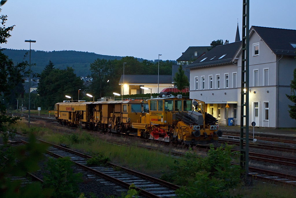 Morgens um kurz nach F�nf am 16.07.2013 im Bahnhof Burbach, an der KBS 462 (Hellertalbahn). hier sind abgestellt: Deutsche Plasser Schotterverteil- und Planiermaschine SSP 100 (Schweres Nebenfahrzeug Nr. 97 16 37 539 17-4) der Schweerbau. Der Schotterpflug wurde 1994 unter der Masch.-Nr. 531 bei der Deutschen Plasser gebaut. und dahinter: Plasser & Theurer Universalstopfmaschine 08 - 475 Unimat 4S (Schweres Nebenfahrzeug Nr. 97 43 42 528 17 - 7) der Schweerbau. Die Stopfmaschine wurde 1996 unter der Masch.-Nr. 1074 bei Plasser & Theurer (�sterreich) gebaut. 

�brigens: Die Aufnahme ist aus der Hand gemacht.
