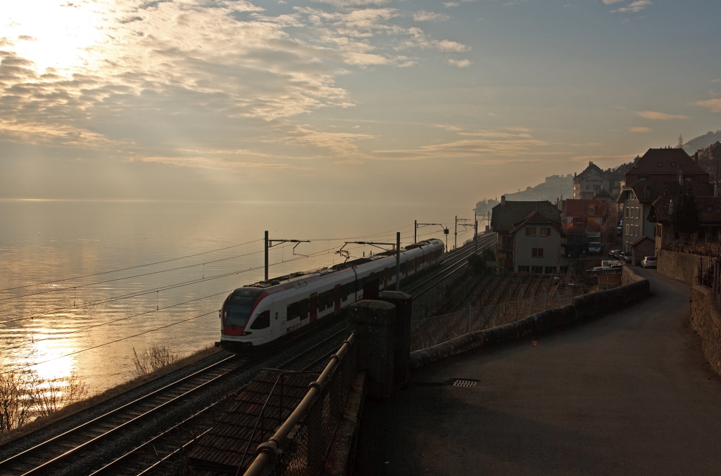 Nachschu�: Stadler FLIRT  RABe 523 015 der SBB (RER Vaudois) als S1 (Villeneuve - Montreux -  Vevey - Lausanne -  Yverdon-les-Bains), hier am 2502.2012 bei St. Saphorin. Diese 4-teiligen Garnituren haben die Achsanordnung BO&acute;2&acute;2&acute;2&acute;Bo, eine Leistung von 2.600 kW am Rad, eine H�chstgeschwindigkeit von 160 km/h und haben 162 Sitzpl�tze.