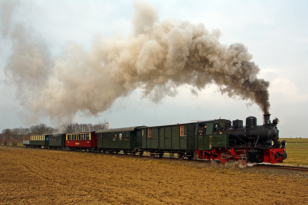 Ostern und Saisoner�ffnung bei der Selfkantbahn - Die Jung Dampflok 20  Haspe  der Selfkantbahn bzw. Interessengemeinschaft
Historischer Schienenverkehr e. V. (IHS) zieht ihren Personenzug am 31.03.2013, hier kurz hinter Birgden nun entlang der freien Felder in Richtung Gillrath.

Die Selfkantbahn ist eine meterspurige Museumsbahn auf einem 5,5 km langen noch erhaltenen Streckenabschnitt zwischen Schierwaldenrath und Gillrath, der ehemaligen Geilenkirchener Kreisbahn (G.K.B.). Sie befindet sich im Westen des Bundeslandes Nordrhein-Westfalen, nahe der holl�ndischen Grenze.