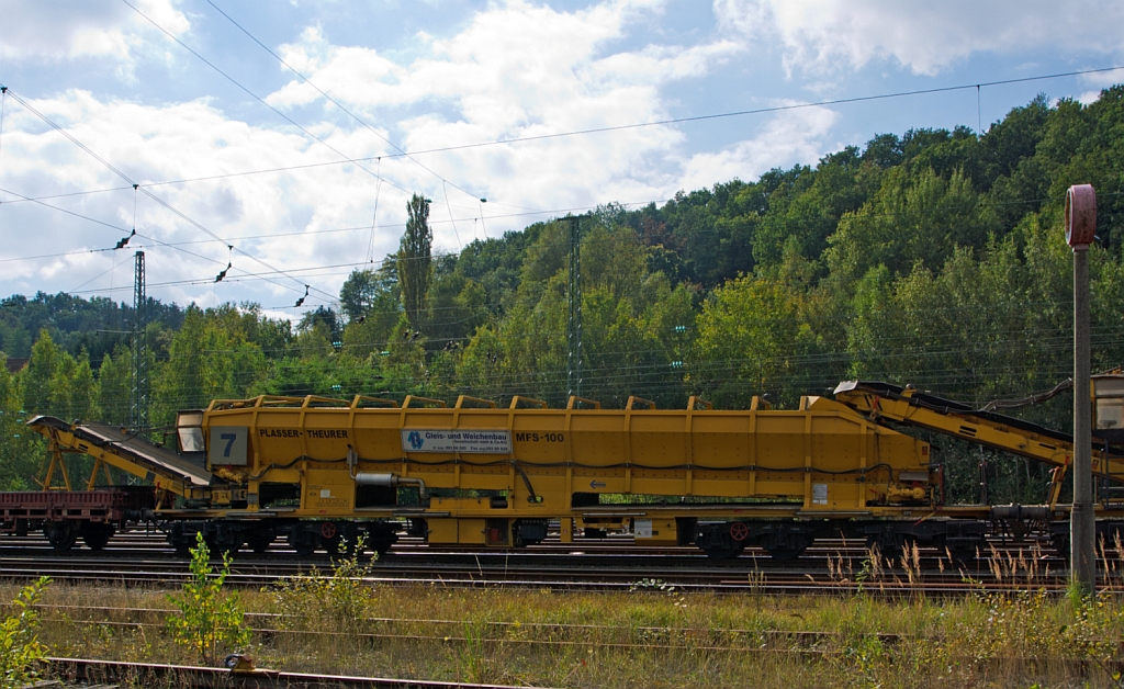 Plasser & Theurer Materialf�rder- und Siloeinheit MFS 100 der MGW Gleis- und Weichenbau-GmbH (Berlin) Nr. 7 (Schweres Nebenfahrzeug Nr. 97 19 29 547 57-0),  abgestellt in Betzdorf/Sieg am 22.09.2012.
Die MFS 100 und dienen zum Transport von Schotter, Abraum und Pufferspeicher bei der Bettungsreinigung bzw.Planumsverbesserung. Hauptvorteil ist der kontinuierliche F�rder-, Speicher- und Entladevorgang. Eine Zusammenstellung von beliebig vielen MFS-Wagen zu einem Zug mit jeweils gew�nschter Speicherkapazit�tist m�glich. Der  F�llvorganges beginnt beim  vordersten Wagen (in Arbeitsrichtung), die folgenden Wagen dienen als F�rderstra�e.
Eine gleichzeitige Entleerung aller MFS-Wagen durch Ausschwenken der Entladeb�nder ist m�glich, zudem eine dosierte Entladung zum Nachbargleis (Baugleis).
Diese Einheit wurde 2002 unter der Fabriknummer 4062 gebaut.
Technische Daten: L�nge �ber Puffer 22.900 mm > L�nge inkl. F�rderband 26.550 mm > Achszahl 8 (2 Drehgestelle mit je 4 Achsen) > max. Achslast (beladen) 18t > Eigenmasse 54 t > max. zul�ssige Zuladung 90 t > Motorleistung 160 kW f�r Antrieb der F�rderb�nder > max. Geschwindigkeit im Zugverband 100 km/h > max. Fassungsverm�gen 68 m�.