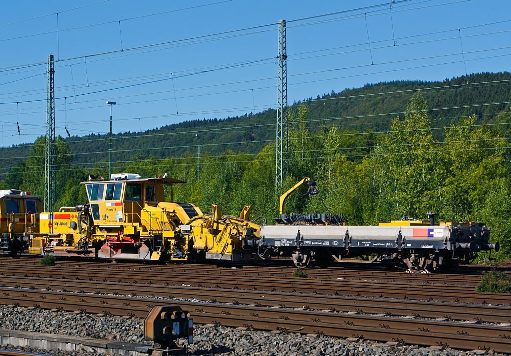 
Plasser & Theurer Schnellschotterplaniermaschine SSP 110 SW   Ploeg 14  (Schweres Nebenfahrzeug Nr. 97 16 46 509 18-4)  der Niederl�ndischen Fa. Strukton Rail b.v. mit einer Niederlassung in Kassel, abgestellt am 08.09.2012 in Betzdorf/Sieg. Die Maschine wurde 2004 unter der Maschine-Nr. 758 gebaut.
  
Techn. Daten:  Gesamtl�nge �ber Puffer 17.050 mm  >  Anzahl der Achsen 2  >  Gewicht 44.000 kg  >  Max. Eigenfahrgeschwindigkeit 100 km/h   >  Leistung 400 kW  (Deutz BF8M 1015C Motor)  >  Spurma� 1.435mm  >  zugelassen f�r Streckenklasse D2 oder h�her.

Schotterpfl�ge werden vor oder nachdem Stopfen des Gleises eingesetzt. Die Maschinen bewirken eine optimale Schotterverteilung und Formen das Profil des Schotterbettes. Dies ist notwendig f�r den Seitenwiederstand des Schotterbettes.

Davor angekuppelt ein Niederbordwagen (27 84 332 0 514-5 NL-SRM).