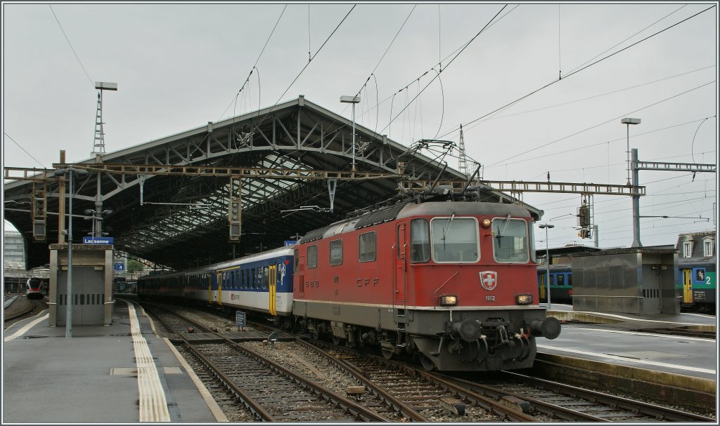 Re 4/4 II 1112 mit einem EW I/II Regionalzug nach Vallorbe bei der Abfahrt in Lausanne. 
12. Juni 2012