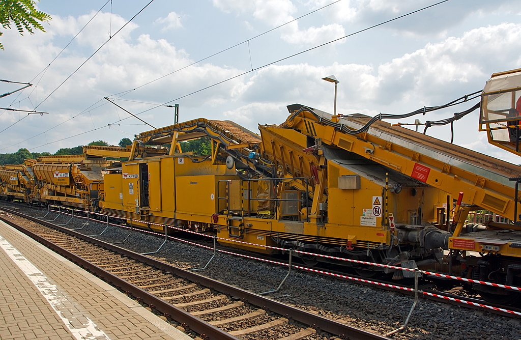 �bergabewagen der GBM Wiebe Gleisbaumaschinen GmbH, Schweres Nebenfahrzeug Nr. 99 80 9410 001 – 8 D-GBM am 13.07.2013 bei Katzenfurt (Lahn-Dill-Kreis) an der KBS 445 (Dillstrecke). 

Die Funktion von dem Wagen kann man hier gut sehen. �ber die fordern MFS Materialf�rder- und Siloeinheiten (bei Wiebe hei�en sie BSW Bunker-Schuttgut-Wagen), worin Neuschotter ist, darauf sind F�rderb�nder montiert. Hinter dem �bergabewagen sind weitere MSF-Wagen in diesen ist PSS-Material (hier Sand bzw. Kies), der letze Wagen gibt das Material an den �bergabewagen und es wird dann weiter mittels der F�rderb�nder oberhalb der anderen Wagen zur Planumsverbesserungsmaschine RPM W 2002 – 2 transportiert und unter das Gleisbett eingebaut.

Der Wagen hat ein Gewicht von ca. 80 t und eine L�nge �ber Puffer von 19.900 mm.

