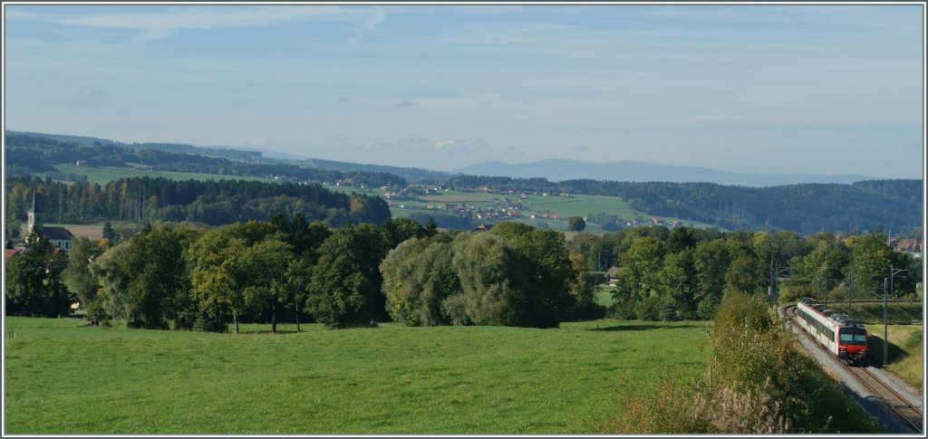 Und ein Blick in die entgegengesetzte Richtung zeigt einen Domino auf dem Weg nach Payerne. Er wird in K�rze bei der Kirche ganz links im Bild vorbeifahren.
Bei Pal�zieux, den 5. Okt. 2012
