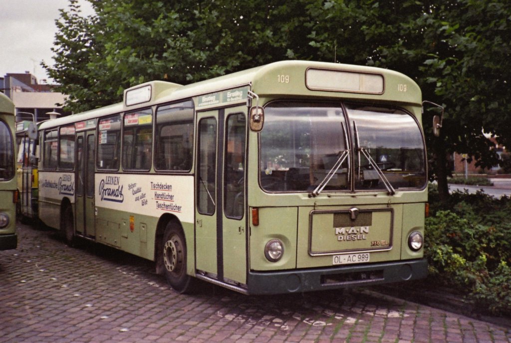 Wagen 109, OL-AC 989, EZ: 1970. Dieses Bild hier pr�sentieren zu k�nnen freut mich besonders, denn es zeigt Wagen 109. Dieser Bus war der erste Standardlinienbus Typ I des Herstellers MAN, der bei den Oldenburger Vorortbahnen eingesetzt wurde. MAN �nderte sp�ter die Typenbezeichnung von 750 HO-SL in SL 192 und sp�ter in SL 200. Im wesentlichen, insbesondere in der �u�eren Erscheinung blieb der Bustyp SL I aber fast unver�ndert und pr�gte so bis in die 90er Jahre das Stadtbild von Oldenburg. Zum Zeitpunkt der Aufnahme im September 1980 war der Bus ziemlich genau 10 Jahre alt und stand kurz vor seinem Ausscheiden. Die Werbung f�r BETTEN GRASHORN und LEINEN BRANDT �bernahm 1981 einer der ersten SL 200 mit St�LB-Front, Wagen 55. Diese Aufnahme entstand im Bundesbahnweg. Sie zeigt, dass die Reservebusse hier zweispurig abgestellt wurden und wie urspr�nglich die Fahrtrichtung im Bundesbahnweg verlief. Nachdem in der Raiffeisenstra�e die Abbiegem�glichkeit am Stadtmuseum in Richtung Pferdemarkt zur�ckgebaut und der Bundesbahnweg teilweise zur Einbahnstra�e wurde, mussten die Busse �ber die Raiffeisenstra�e anfahren und parkten dann in Fahrtrichtung Moslestra�e.