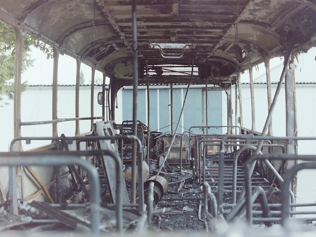 Wagen 28. Bei genauerer Betrachtung dieses Bildes lassen sich viele Details in dem Wrack entdecken. Im Vordergrund auf den Resten eines Doppelsitzes liegt eine verbogenen Motorklappe aus dem Fu�boden, in der Mitte des Busses lehnt die Heckklappe. Das Lenkrad ist bis auf einen kleinen Metallkranz verschmort. Daf�r sind der Fahrersitz, Teile des Armaturenbrettes und das Mikrofon f�r Funk und Borddurchsagen erkennbar. Ganz vorne im Bus, neben der Heizung, h�ngt noch der Feuerl�scher in seiner Halterung. Auf dem Boden, in H�he des Radkastens liegt der vordere Fahrscheinentwerter. Im �brigen hat das Feuer s�mtliche Innenausbauten vernichtet, soda� ein guter Blick auf die Rahmenbauweise m�glich ist. 