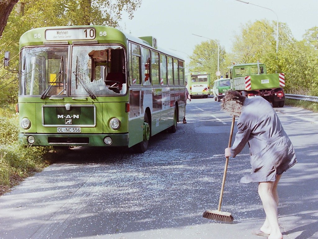 Wagen 56.  Jumbo  nannten die Pekolaner �brigens nicht den freundlichen Mitarbeiter, der hier Scherben zusammen fegt, sondern Wagen 404, den firmeneigenen Pannenservice- und Abschleppwagen. An diesem Tag waren auf der Butjadinger Stra�e, in der Kurve vor der Br�cke �ber die Autobahn 29, der stadteinw�rtsfahrende Wagen 56 und der Richtung Wahnbek fahrende Wagen 67 (im Hintergrund) zusammengesto�en. Obwohl der Sachschaden an beiden Bussen erheblich und wohl auch Personenschaden zu beklagen war, ...