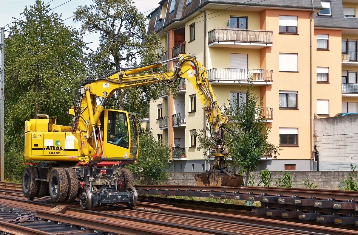 . Der Zweiwegebagger ATLAS 1404 MZ beim Stapeln fertig verschraubter Schienenstr�nge am 25.08.2015 in Schieren. Vielen Dank an der Baggerfahrer f�r das nette Beiseiter�umen eines Drahtgestells, welches die Sicht auf das Fahrzeug verdeckte. (Hans)  
