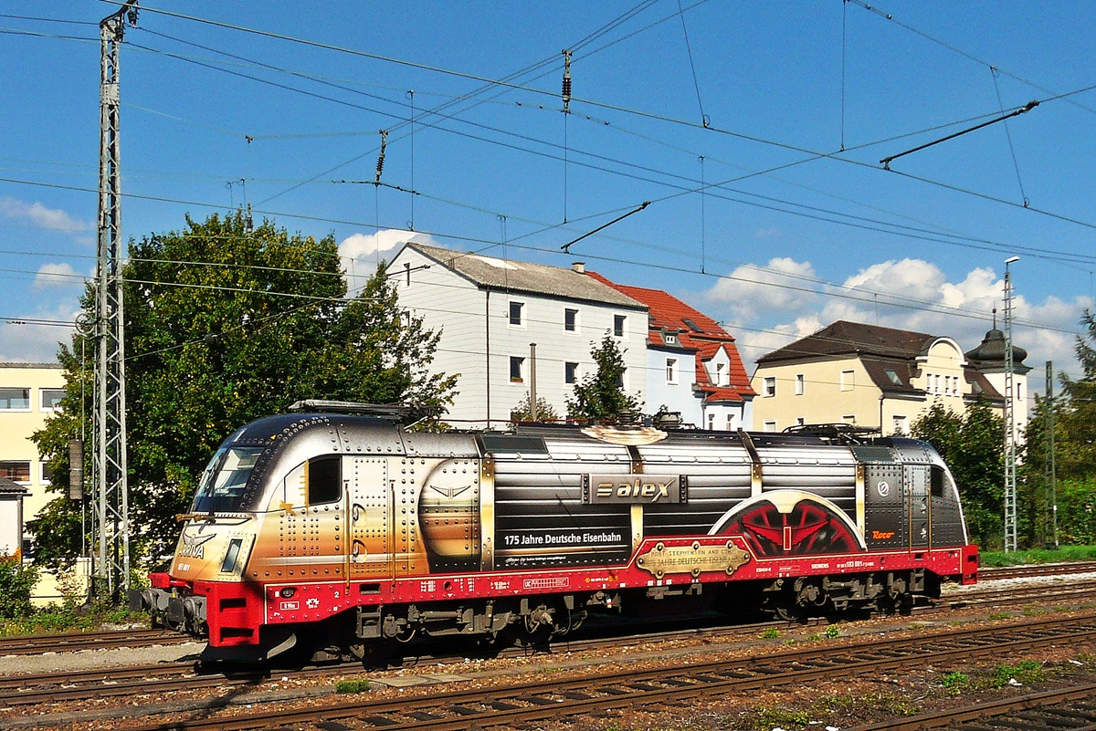 . Ein Aus-dem-Zug-Bild - Die sch�ne ALEX Lok 183 001-7  175 Jahre Eisenbahn in Deutschand  war am 11.09.2010 im Hauptbahnhof von Regensburg abgestellt, aber leider so ung�nstig, dass ich warten musste, bis wir zur�ck nach Passau fuhren. Zum Gl�ck konnte man die Fenster �ffnen und so gelang mir ein Aus-dem-Zug-Foto von der tollen Lok. (Jeanny)

Das Design ist angelehnt an die Lokomotive  Adler  und wurde von der �sterreicherin Gudrun Geiblinger entworfen.

Zum Schlu� noch die technischen Daten der Lok:

Hersteller: Siemens, M�nchen
Fabriknummer: 21130 
Abnahmedatum: 05.10.2007 
UIC-Nr.: 91 80 6183 001-7 D-VBG 
EBA-Nr.: EBA 07E08G 001
Eigent�mer: Hannover Mobilien Leasing



