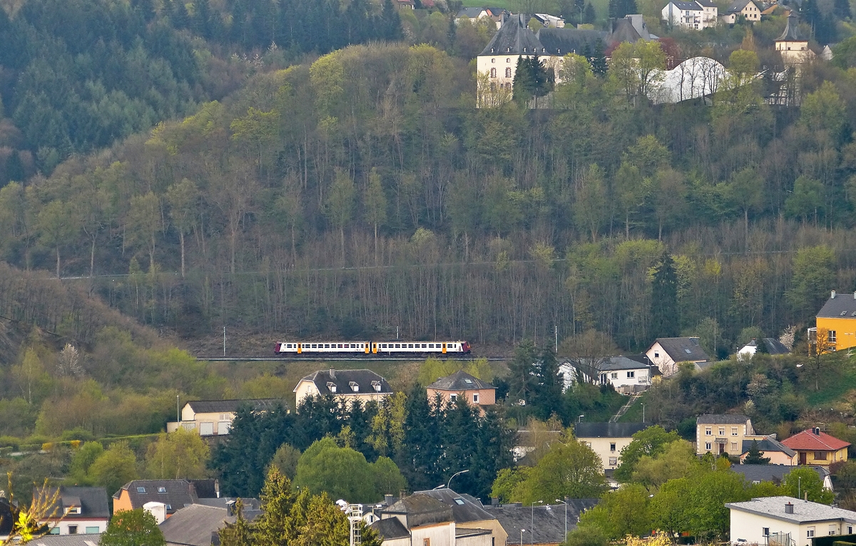 . Eine etwas andere Sicht auf Wiltz - Zwischen Erpeldange und Weidingen kann man die Bahnstrecke Kautenbach- Wiltz einsehen. Ein unbekannt gebliebener Triebzug der Série 2000 hat vor kurzem den Bahnhof von Wiltz verlassen und ist nun als RE 1736 unterwegs nach Kautenbach. Oben ist das Schloss von Wiltz zu sehen, sowie einige Häuser der Oberstadt, während die Häuser unten im Bild zu Weidingen/Wiltz gehören. 28.04.2015 (Hans)