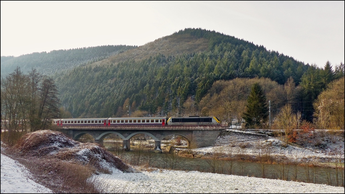 . Im leichten Gegenlicht zieht die 3002 den leicht versp�teten IC 113 Luxembourg - Liers �ber die Sauerbr�cke in der N�he von Michelau. So richtig winterlich sieht es im Sauertal nicht aus. 18.01.2016 (Jeanny)