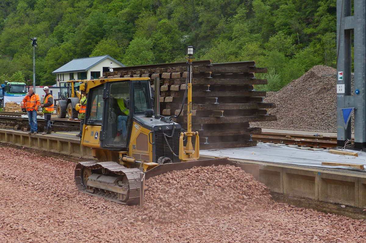 . John Deere 450J LT mit GPS Ansteuerung, bei Schotterplanierungsarbeit im Bahnhof Kautenbach.  17.05.2016. 