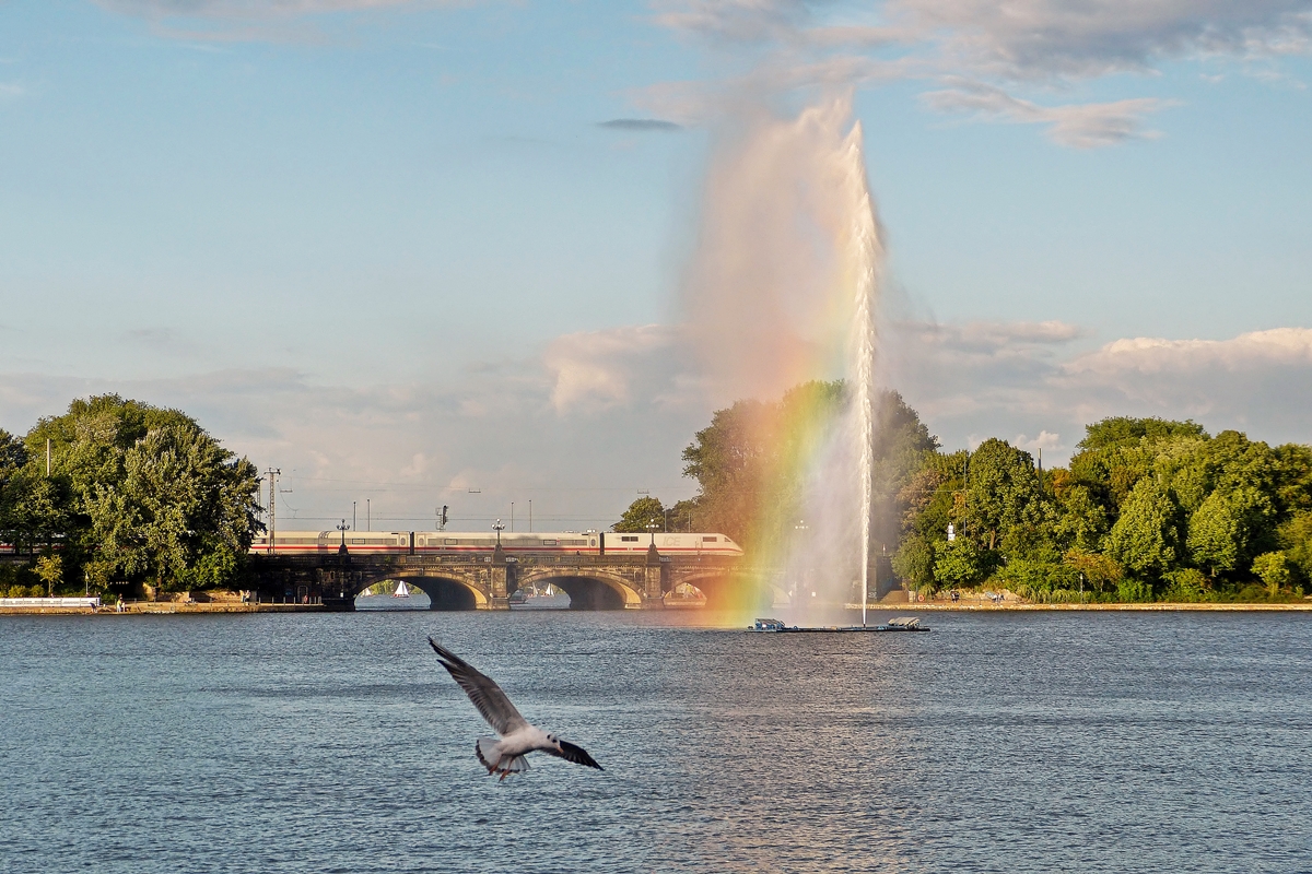 . Lichtspielereien an der Lombardsbr�cke in Hamburg -  W�hrend die Fontaine der Binnenalster am 17.09.2013 einen stimmungsvollen k�nstlichen Regenbogen erzeugt, �berquert ein ICE 1 die Br�cke auf seinem Weg zum Hamburger Hauptbahnhof. (Jeanny)