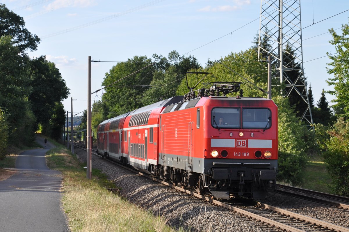 143 189 fuhr am 11.08.2018 ihre Ersatzgarnitur als RB 15277 nach Frankfurt (Main) Hbf, hier bei Wörsdorf. Der Ersatzzug bestand aus einem Fahrradwagen, einem gemischtklassigen Doppelstockwagen sowie einem modernisierten Steuerwagen der 3. Generation.
Vielen Dank an den Lokführer für den Lichtgruß! 