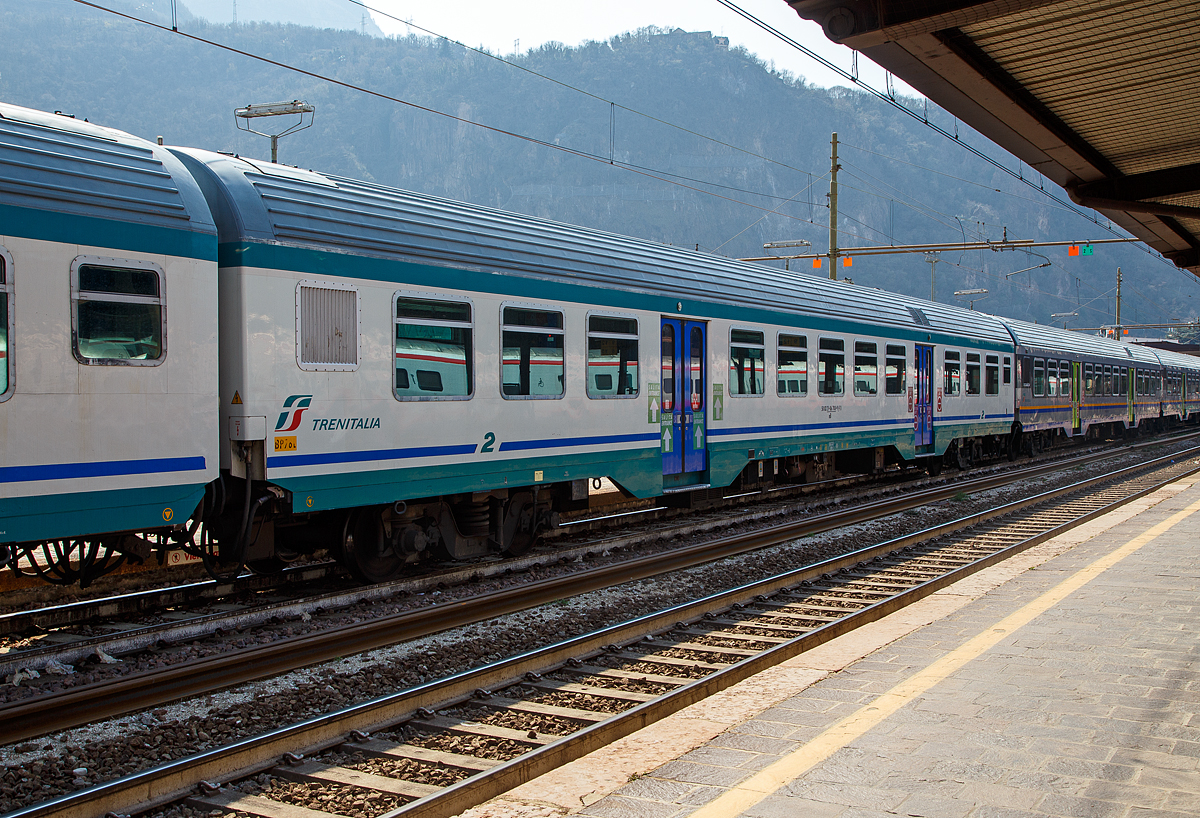 2. Klasse MDVC-Reisezugwagen (MDVC steht für Medie Distanze Vestiboli Centrali, deutsch für Mittlere Entfernungen in Ballungsräumen) 50 83 21-86 708-9 I-TI der Trenitalia, der Gattung nB am 26.03.2022 im Zugverband im Bahnhof Bozen / Bolzano.

Die den Wagen handelt es sich um in Italien hergestellte Eisenbahnwaggons die speziell für den Einsatz für mittlere Entfernungen wie z.B. RE (Regionalexpress Züge).

TECHNISCHE DATEN:
Spurweite: 1.435 mm
Länge über Puffer: 26.400 mm
Breite: 2.825 mm
Höhe: 3.965 mm
Drehzapfenabstand: 19.000 mm
Achsstand im Drehgestell: 2.400 mm
Laufraddurchmesser : 860 mm (neu)
Fußbodenhöhe: 1090 mm
Eigengewicht: 40 t
Sitzplätze: 82 (2. Klasse)
Höchstgeschwindigkeit: 160 km/h
Bremsbauart: Freno WU-R 
