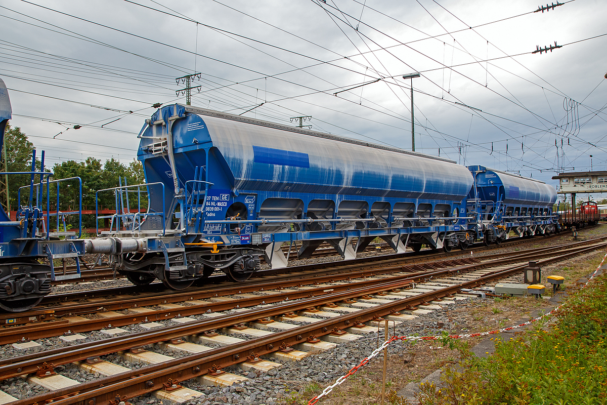 
4-achsiger 82,5 m³ Drehgestell-Trichtermittenentladewagen, 37 84 0839 001-1 NL- WASCO der Gattung Tadns, der Wascosa AG, am 04.09.2020 im Zugverbund beim Rangieren in Koblenz-Lützel.

Der mit einer hohen bilateral kontrollierten Schwerkraftentladung und einem zu öffnenden Dach ausgestattete Wagen ist für den Transport von Kalksteinen und anderen Schüttgütern, die vor Witterungseinflüssen geschützt werden müssen, konzipiert worden. Das Schüttgut wird mit Hilfe der Schwerkraft über die Dachöffnung eingefüllt. Das kontrollierte Entladen wird manuell durchgeführt. Die Entleereinrichtung besteht aus 4 Auslauftrichtern die mit je 2 Klappen verschlossen sind und manuell per Hebel, einzeln von den beiden Plattformen an den Wagenenden aus betätigt werden. Die Komplette Entladung des Wagens ist durch Öffnung auf nur einer Seite möglich. Die Entladung des Wagens erfolgt auf Förderbändern oder in unterirdische Bunker.


TECHNISCHE DATEN:
Hersteller: Astra Rail Industries (Rumänien) 
Spurweite: 1.435 mm
Länge über Puffer : 19.040 mm
Drehzapfenabstand: 14.000 mm
Achsabstand im Drehgestell: 1.800 mm
Eigengewicht: 24.680 kg
Höchstgeschwindigkeit:  100  km/h (beladen) / 120 km/h (leer)
Maximales Ladegewicht: 65,3 t (Streckenklasse D oder höher)
Kleinster bef. Gleisbogenradius:   75 m
Rauminhalt: 82,5 m³
Ladeöffnung: 15.080 x 1.200 mm
Dach: Spritzwasserfestes Hub-/Schwenkdach mit Handbetätigung
Drehgestell-Typ: Y25Lsd-KP1
Laufraddurchmesser: 920 mm (neu)
Bremse: KE-GP-A
Intern. Verwendungsfähigkeit: TEN GE