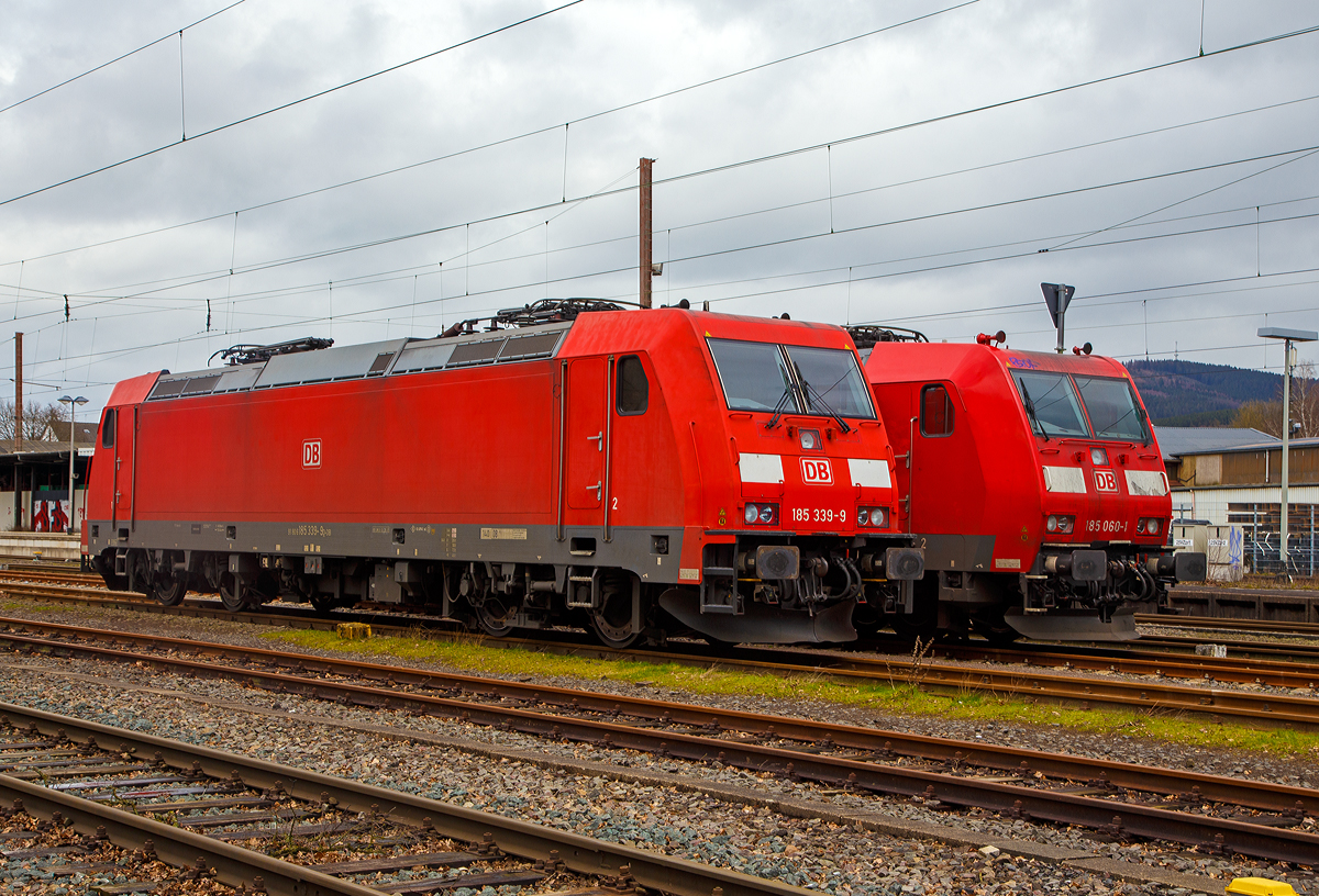 Abgestellt in Kreuztal am 13.03.2020:
Die 185 339-9 (91 80 6185 339-9 D-DB) eine Bombardier TRAXX F140 AC2 (Fabriknummer 34221 Baujahr 2008) und die 185 060-1 (91 80 6185 060-1 D-DB) eine Bombardier TRAXX F140 AC1 (Fabriknummer 33469 Baujahr 2002), beide von der DB Cargo AG.

Hier sieht am gut den optischen Unterschied zwischen der TRAXX F140 AC2 (Baureihe 185.2) und der Vorgängerversion der TRAXX F140 AC1 (Baureihe 185.0). Man sieht es neben den Puffern deutlich, die Ausklinkung und die Trittstufen. Die Griffstangen sind bei der BR 185.2 eingelassen und bis zur OK Tür hochgezogen. Zudem gibt es vorne beim Rangiertritt zusätzliche Griffstangen. 

Die TRAXX 2 ist eine Weiterentwicklung der Traxx-Baureihen, gegenüber welchen sie als augenfälligste Änderung einen überarbeiteten Lokkasten besitzt. Die Änderung erfolgte um den neuen, strengeren Sicherheitsnormen bezüglich Crashfestigkeit zu genügen und ist an leicht nach unten gezogenen Ecken am Lokkasten und den Frontklappen zum Ausbau der Klimaanlage zu erkennen. Geändert wurde auch die Umrichteranlage.
