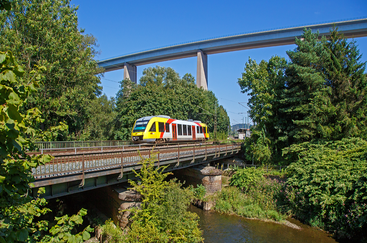 
Am Rückweg kamen wir am Sonntag wieder durch Eiserfeld, so habe ich nochmal die Fotostelle an der Siegbrücke aufgesucht...
Der VT 203 ABp (95 80 0640 103-7 D-HEB) ein Alstom Coradia LINT 27 der HLB (Hessische Landesbahn) am 30.08.2015, als RB 95  Sieg-Dill-Bahn   (Siegen - Au/Sieg / Umlauf HLB 61758). Der Dieseltriebwagen hat gerade den Bahnhof Siegen-Eiserfeld verlassen und überquert nun gerade die Sieg, welche er noch öfter auf seiner Fahrt nach Au überqueren wird.

Im Hintergrund wieder die 105 m hohe Siegtalbrücke der A45 (Sauerlandlinie).
