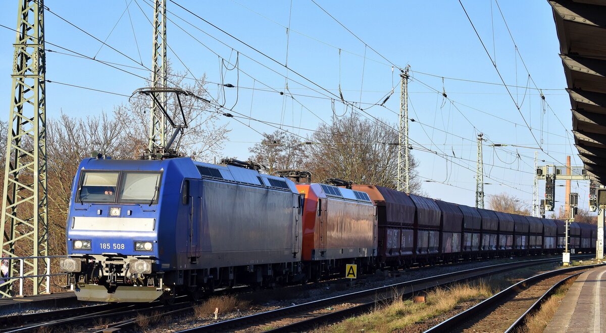 ArcelorMittal Eisenhüttenstadt Transport GmbH mit den geleasten ATLU Loks  185 508  [NVR-Nummer: 91 80 6185 508-9 D-ATLU] + der eigenen  145-CL 203  [NVR-Nummer: 91 80 6145 099-8 D-EKO]  und einem Ganzzug Selbstentladewagen (leer) Richtung Hamburg am 03.03.26 Höhe Bahnhof Magdeburg-Neustadt.